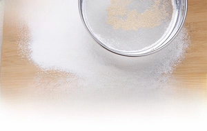 Close-up of flour being sifted through a high-quality 60-mesh stainless steel sieve