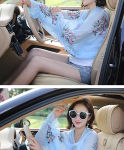 Close-up of light blue chiffon sun protection shirt with pink floral embroidery on sleeve