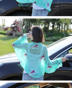 Detail view of a green chiffon cardigan featuring pink flower and butterfly embroidery