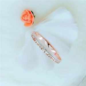 Elegant rose gold Roman numeral bangle with sparkling zircon stones on soft background