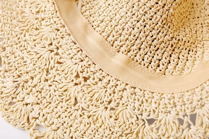 Détail d'un chapeau de paille montrant les bords ondulés et le ruban intérieur