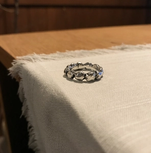Detail of minimalist 925 silver ring featuring irregular lava texture on white linen cloth
