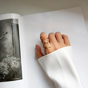Detailed view of a gold-plated leaf wrap ring worn on finger with elegant aesthetic