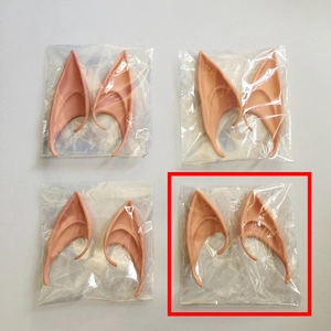 Detailed view of four pairs of skin-colored latex elf ears in protective OPP packaging