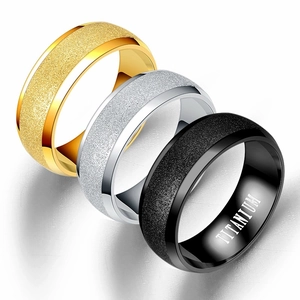 Macro detail of stacked titanium rings showing sandblasted matte texture in gold, silver and black