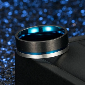 Detail of blue and black brushed stainless steel men's ring on a textured gift box