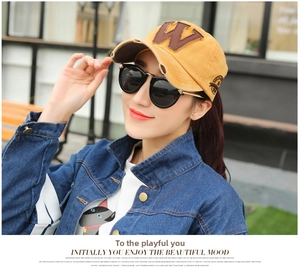 Detail of ginger washed cotton baseball cap with vintage W embroidery on a model outdoors