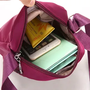 Spacious burgundy nylon crossbody bag showing main compartment with multiple storage pockets