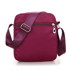 Purple nylon crossbody bag with multi-compartments and adjustable strap on white background