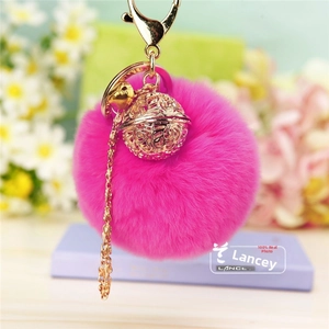 Détail de porte-clés pompon rose fuchsia en fausse fourrure avec boule en métal doré