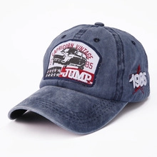 Detail of blue washed denim baseball cap with vintage car patch and 1985 embroidery
