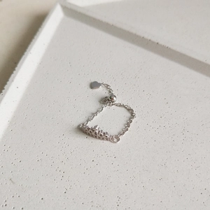Detail of adjustable S925 sterling silver crown chain ring with a heart charm pendant