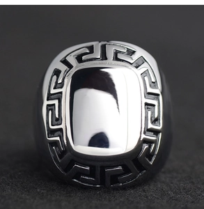 Macro shot of silver titanium ring featuring Greek meander patterns and a polished mirror surface