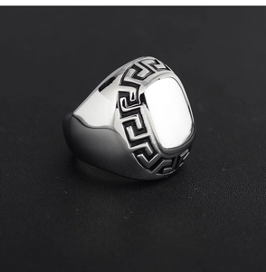 Macro shot of silver titanium steel ring featuring classic Greek meander engraved pattern