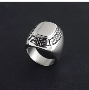 Macro detail of silver signet ring featuring vintage Greek key pattern on polished steel