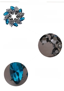 Detail of flower brooch with blue marquise crystals and 3D rhinestones on silver metal