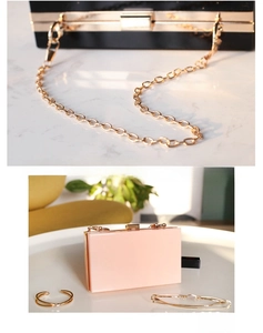 Detail of acrylic box evening clutch with gold metal frame and detachable chain strap