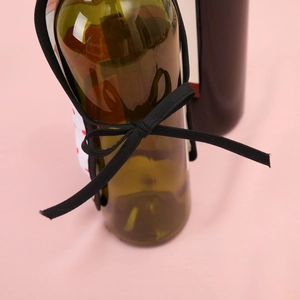 Detailed view of mini Christmas apron wine bottle cover with red festive prints