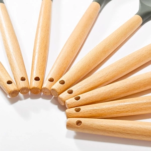Dark gray silicone kitchen utensil set with natural wooden handles on white background