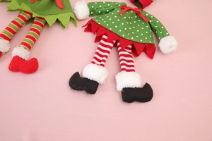 Détail des housses de bouteille elfe de Noël montrant les jambes rayées et le tissu
