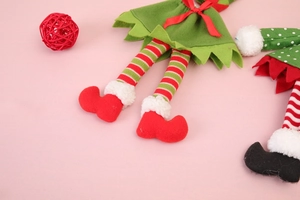 Détail de la housse de bouteille elfe de Noël montrant la jupe en feutre et les jambes