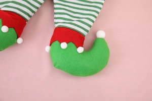 Dettaglio del sacchetto regalo gambe di elfo di Natale in tessuto a righe e feltro con pompon