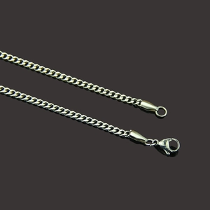 Detailed close-up of polished silver Cuban link chain with lobster clasp and round ring buckle