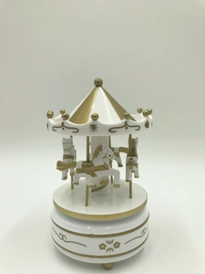 Classic white and gold carousel music box with rotating horses on a clean background