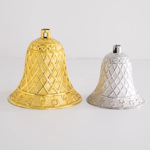 Detail of gold and silver Christmas bell ornaments with diamond pattern texture on white