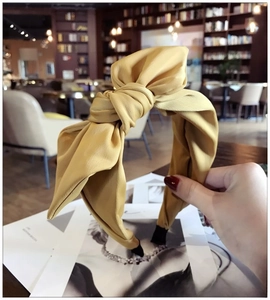 Close-up of ginger yellow fabric headband with elegant bow knot and wide side texture