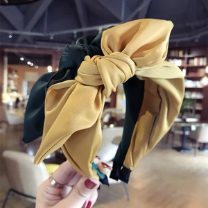 Two-tone yellow and dark green fabric headband featuring a large stylish bow knot