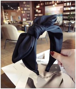 Detailed view of the black satin oversized bow headband with a vintage silky texture