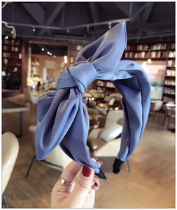 Macro shot of blue fabric oversized bow headband featuring matte texture and side pads
