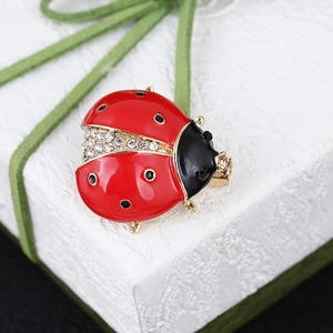 Detail of ladybug brooch featuring red enamel wings and sparkling inlaid rhinestones