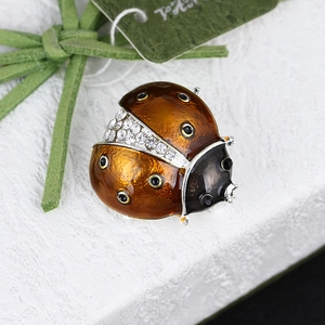Macro shot of ladybug brooch with amber enamel wings and sparkling diamond accents