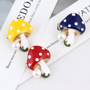 Detailed view of three colorful mushroom pins with white dots and pearl accents