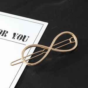 Polished gold infinity shape hair clip shown at a 45-degree angle on gift card