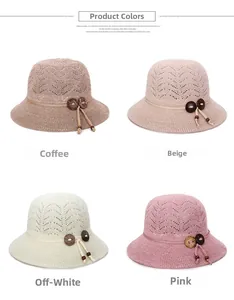 Detail of woven cloche hats in coffee, pink, and cream with decorative wooden buttons