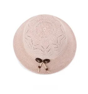 Top view of hollow woven sun hat with decorative wooden buttons and fine hemp rope detail