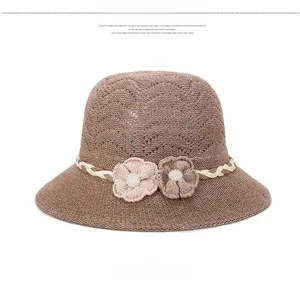 Détail d'un chapeau cloche marron respirant avec fleurs tricotées et perles centrales