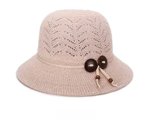 Close-up of hollow knit sun hat with decorative wooden beads and side tie cord details