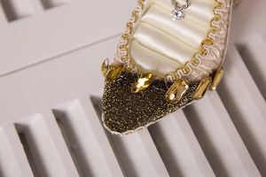 Detailed macro view of golden high heel jewelry organizer with crystals and satin lining