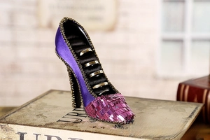 Detail of high heel ring holder with purple silk fabric and pink sequin accents