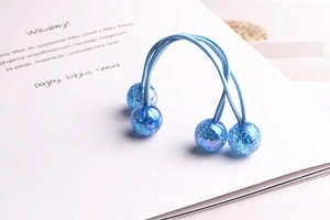 Close-up of two blue elastic hair ties with sparkling beads containing glitter