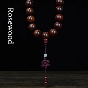 Authentic Rosewood car hanging prayer beads with natural wood grain on a black background