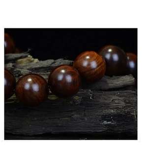 Macro shot of polished red rosewood prayer beads with natural wood grain patterns