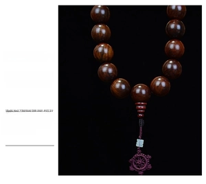 Detailed shot of polished Rosewood Buddhist beads with handcrafted purple woven tassel