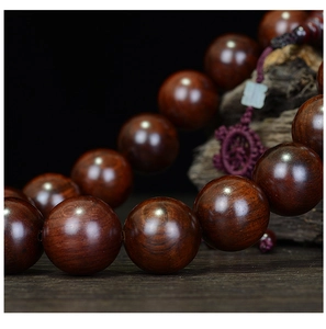Macro close-up of polished Red Rosewood beads showing natural grain and oily texture