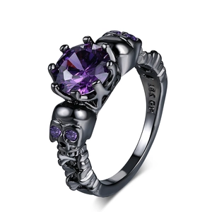 Macro detail of gothic black skull ring with large purple zircon and 18K GP hallmark