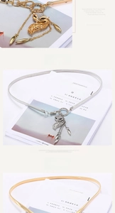 Detail of elegant gold and silver leaf metal belts with fox and tassel pendant charms